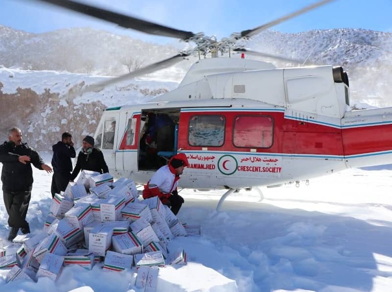 انتقال بسته‌های غذایی توسط هلال احمر با بالگرد به روستاهای محاصره در برف پاوه